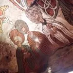 Colorful wall fresco showing several men in striped robes with folded hands in prayer next to a decorative knotwork design