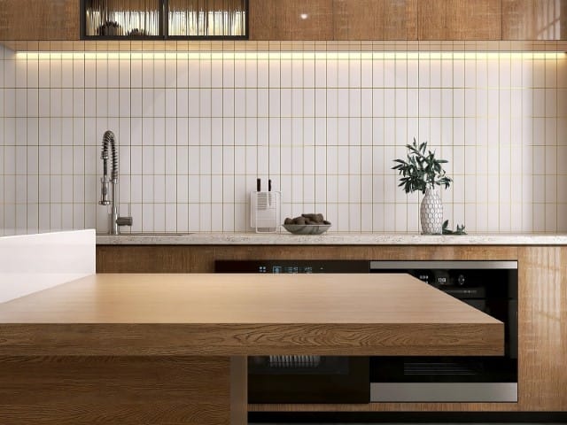 Modern kitchen with wooden island white tiled backsplash stainless steel faucet and built in oven
