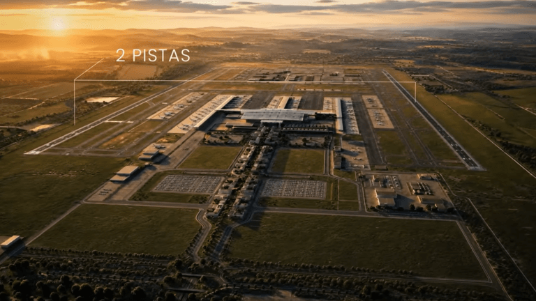 Aerial view of a large airport at sunset showing two parallel runways and a central terminal with surrounding buildings