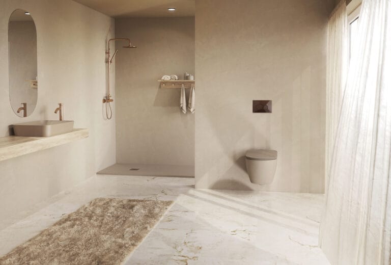Large beige tinted bathroom with open shower area wall mounted sink and a wall hung toilet by a windowed wall and sheer curtains