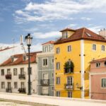 Colorful row of pastel houses with red tile roofs under a bright blue sky a vintage street lamp in the foreground