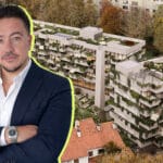 Businessman in a navy suit with arms crossed neon outline set against a green roofed apartment building backdrop