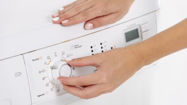 Persons hands set a washing machinedryer dial to a program with visible Special and Time Manager labels on the control panel