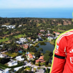 Aerial view of a coastal residential area with houses trees and a small lake plus a large cutout of a footballer in a red Benfica jersey on the right outlined in yellow