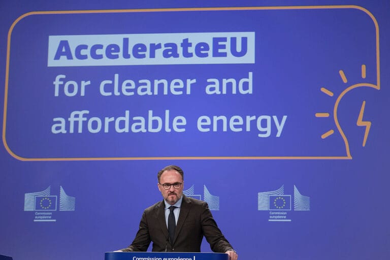 Man in a suit delivering a speech at a podium with a backdrop reading AccelerateEU for cleaner and affordable energy and EU logos in the background