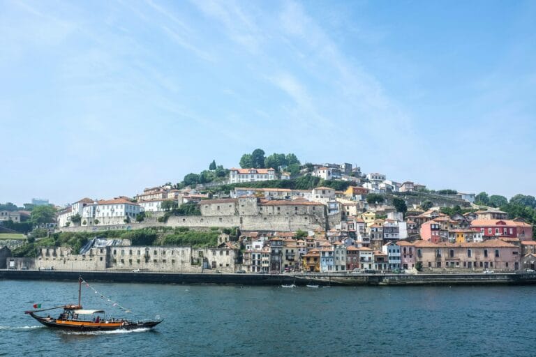 Coastal hillside town along the water with a small boat in the foreground