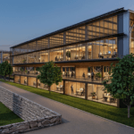 Modern glass front office building at dusk with illuminated interiors and people working inside visible through large windows